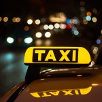 segno-giallo-e-nero-di-taxi-posto-sopra-un-auto-di-notte