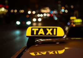 segno-giallo-e-nero-di-taxi-posto-sopra-un-auto-di-notte