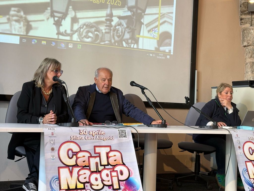 Tre relatori al tavolo durante una conferenza stampa sul Cantamaggio 2025, con un banner del festival in primo piano.