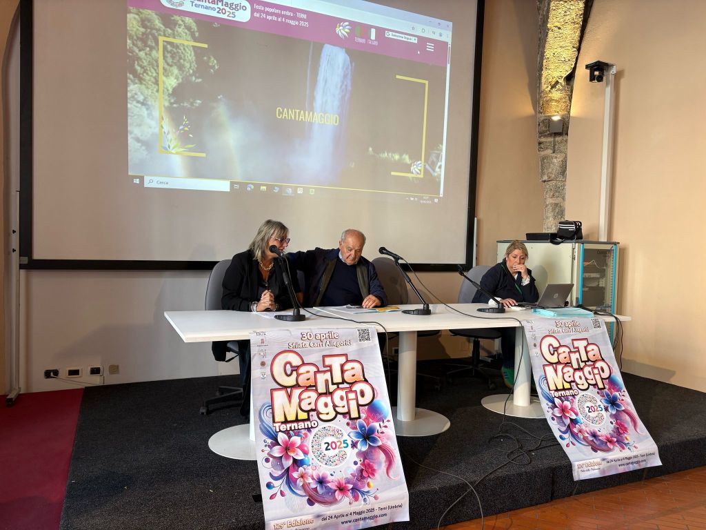 Conferenza stampa sul Cantamaggio Ternano 2025, con tre relatori seduti a un tavolo e un banner del festival sul tavolo.