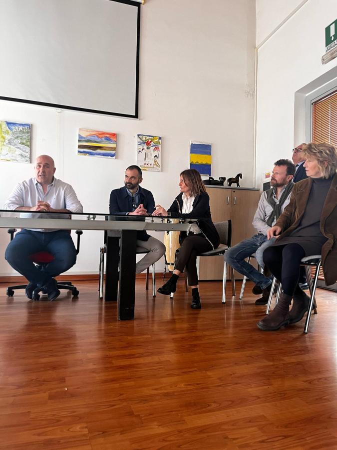 Incontro istituzionale nella struttura socio-sanitaria con il Sindaco di Terni, Stefano Bandecchi, e vari membri della cooperativa La Speranza, seduti attorno a un tavolo durante una discussione.