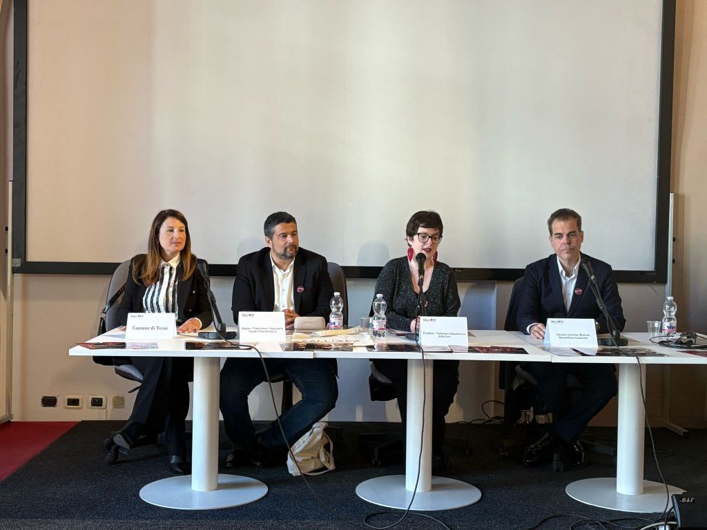 Panel discussion with four speakers seated at a table. Presenters discussing topics with microphones in a conference setting.