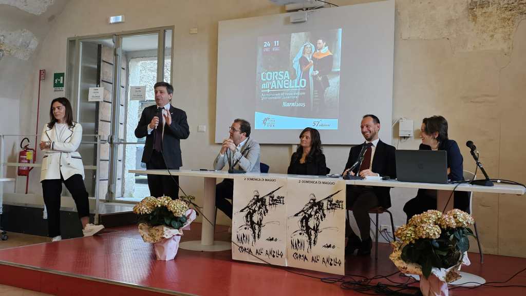 Presentazione della Corsa all'Anello di Narni, con relatori in una sala conferenze, annunciando l'evento storico in programma.