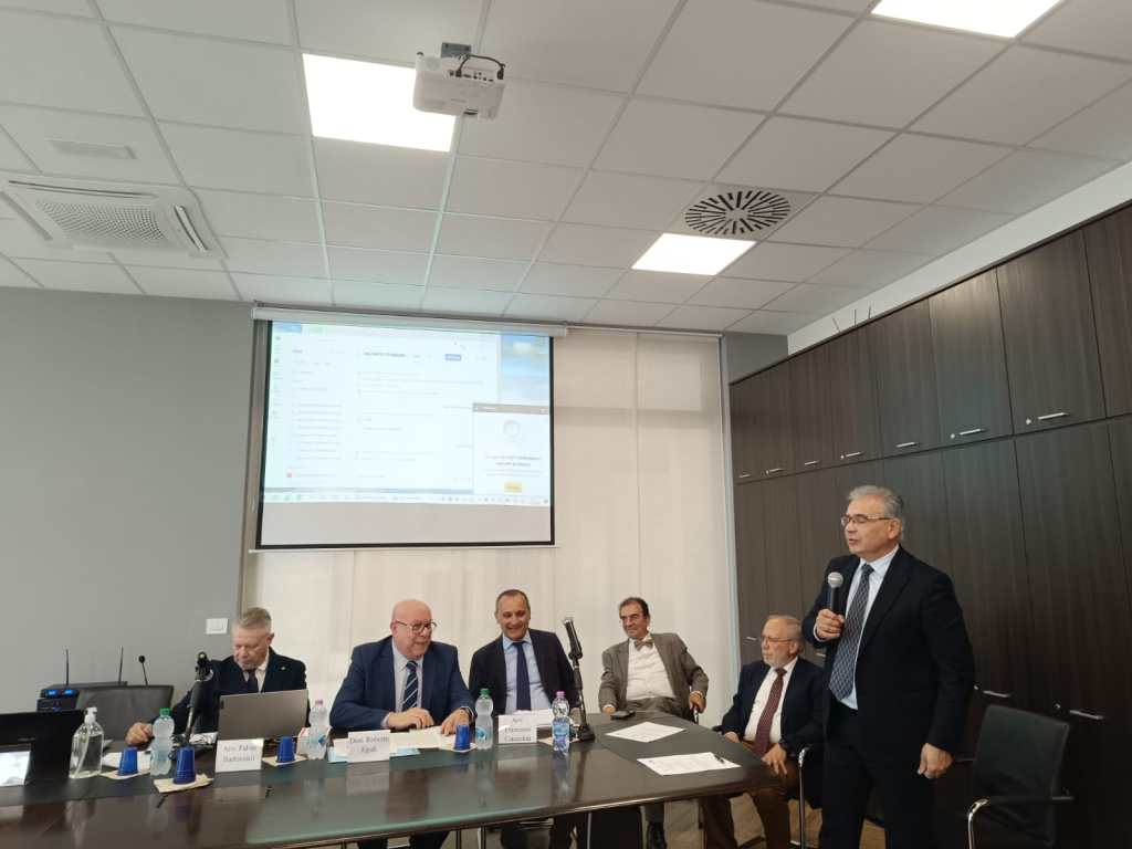 Un convegno giuridico in corso presso la Fondazione Forense, con relatori al tavolo e un proiettore in evidenza.