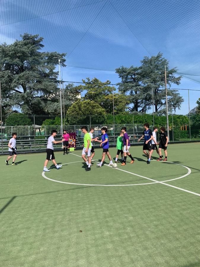 Giovani calciatori si stringono la mano dopo una partita di calcio nel torneo di beneficenza.