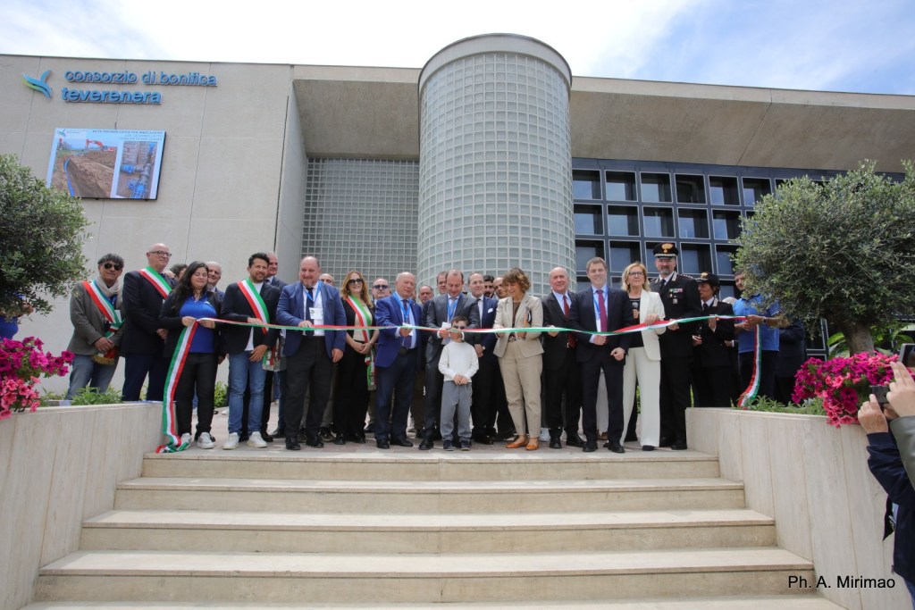Cerimonia di inaugurazione della nuova sede del Consorzio di Bonifica Tevere-Nera, con diversi partecipanti che tengono un nastro pronto per il taglio all'ingresso dell'edificio.