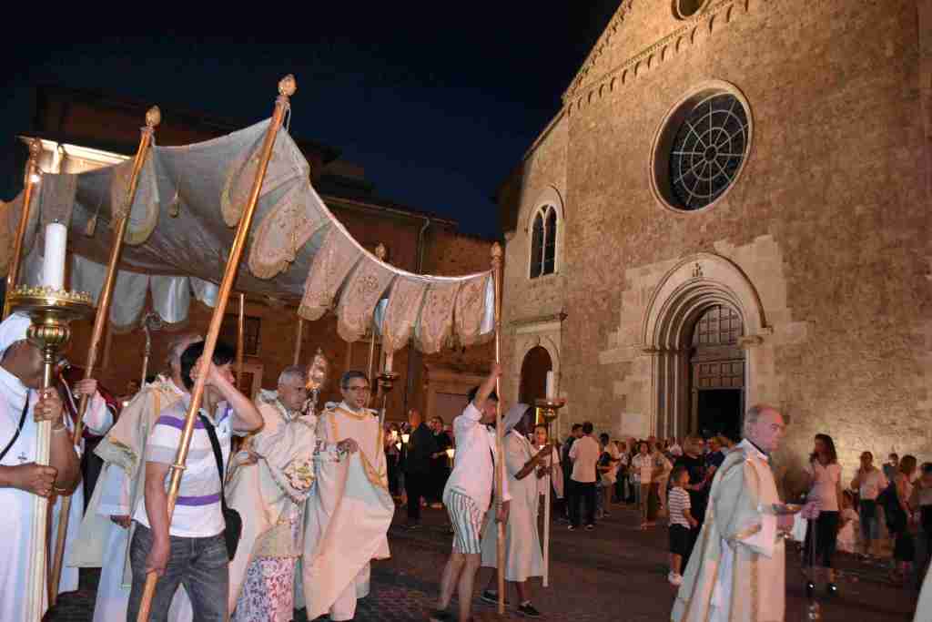 Processione eucaristica durante la celebrazione del Corpus Domini a Terni, con sacerdoti e fedeli che portano un grande baldacchino davanti alla Cattedrale.