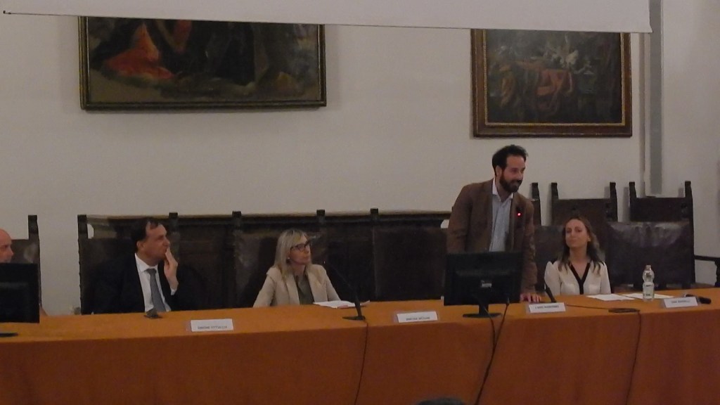 Un incontro dei giovani albergatori di Federalberghi in corso all'abbazia di San Pietro a Perugia, con diversi relatori al tavolo e un pubblico in attesa.