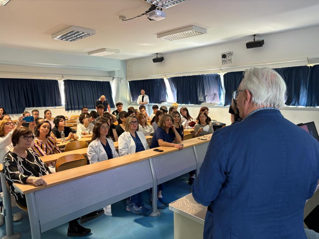 Una conferenza stampa in aula con studenti e insegnanti, dedicata a un progetto sulla donazione di organi e tessuti, con relatori e partecipanti che ascoltano attentamente.