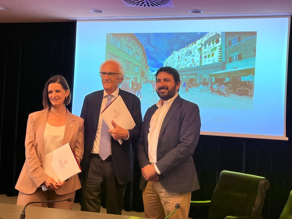 Presentazione del telo d'artista di Mimmo Paladino per il palazzo Baldeschi di Perugia, con tre relatori in primo piano.