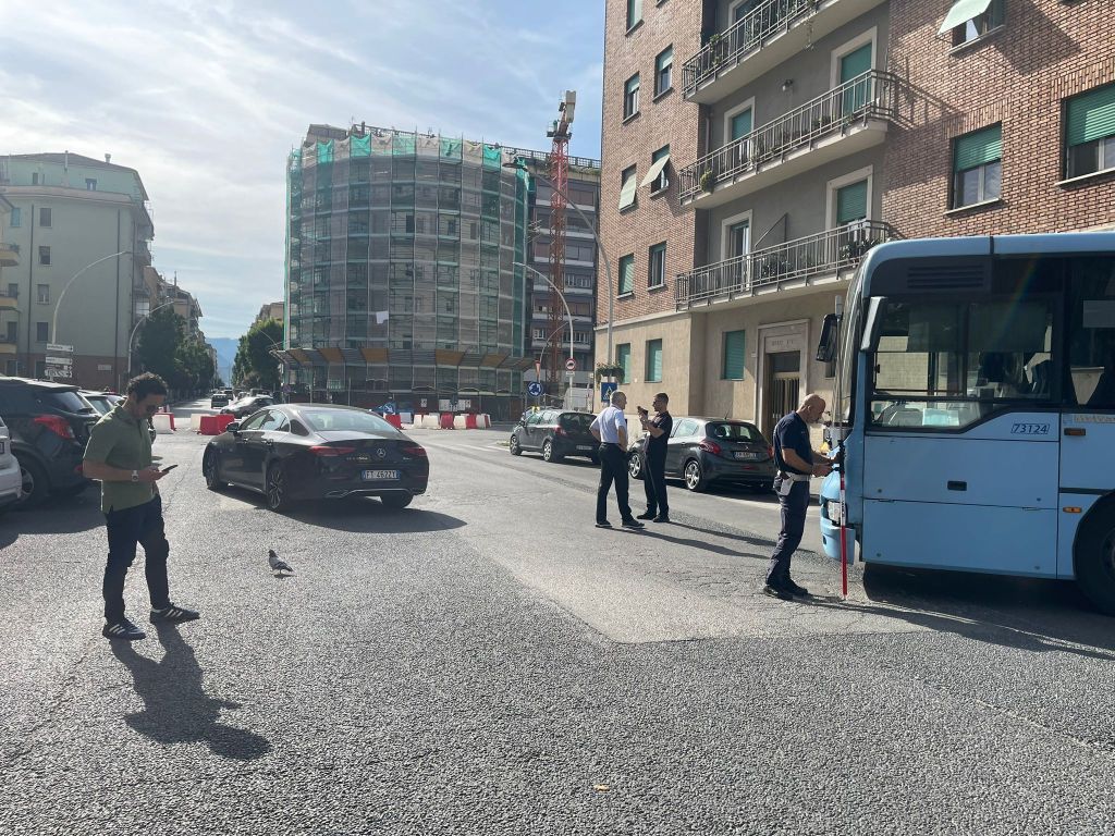 Incidente stradale all'incrocio tra via Borsi e via Battisti a Terni, con un autobus e un'autovettura coinvolti, mentre la polizia locale gestisce la situazione.