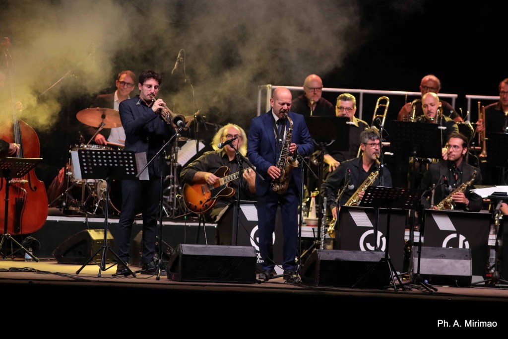 A jazz band performing on stage with various musicians, including a trumpet player and a saxophonist, surrounded by smoke and musical instruments.