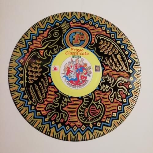 Un disco decorato con un design colorato, che presenta un'aquila e un cerchio centrale con la scritta 'Primo Classificato 2021'.