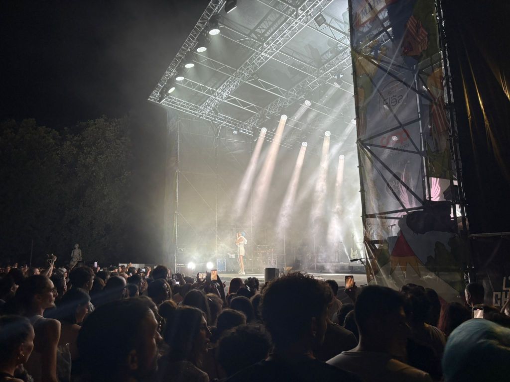 Rose Villain si esibisce sul palco di Umbria Che Spacca, illuminato da potenti riflettori, con un pubblico entusiasta che canta e balla.