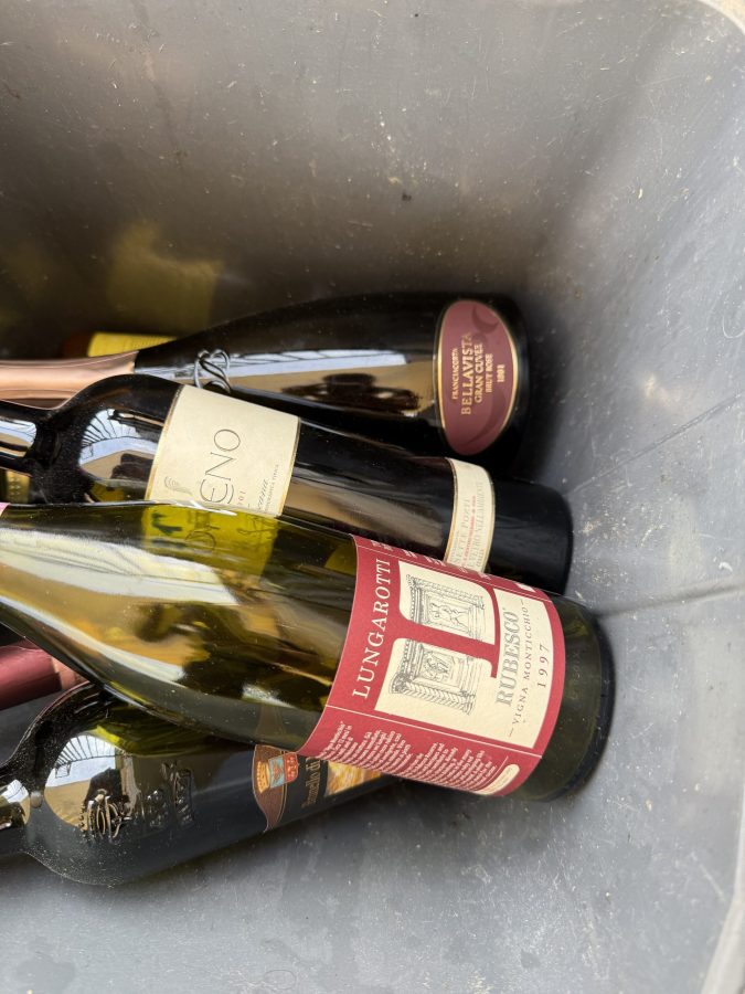 Una selezione di bottiglie di vino in una vaschetta, visibili etichette di vari produttori.