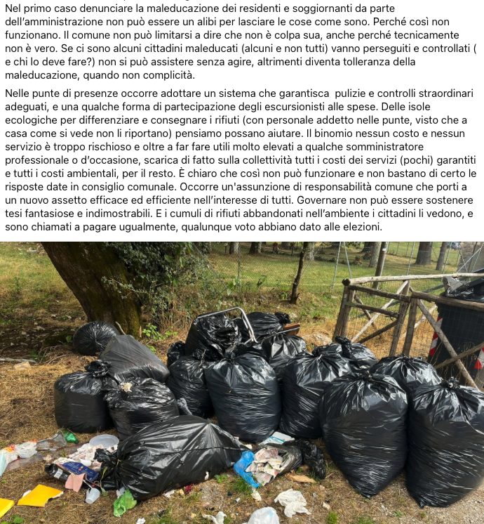 Cumuli di sacchi neri di rifiuti abbandonati in un'area verde, con rifiuti sparsi intorno.