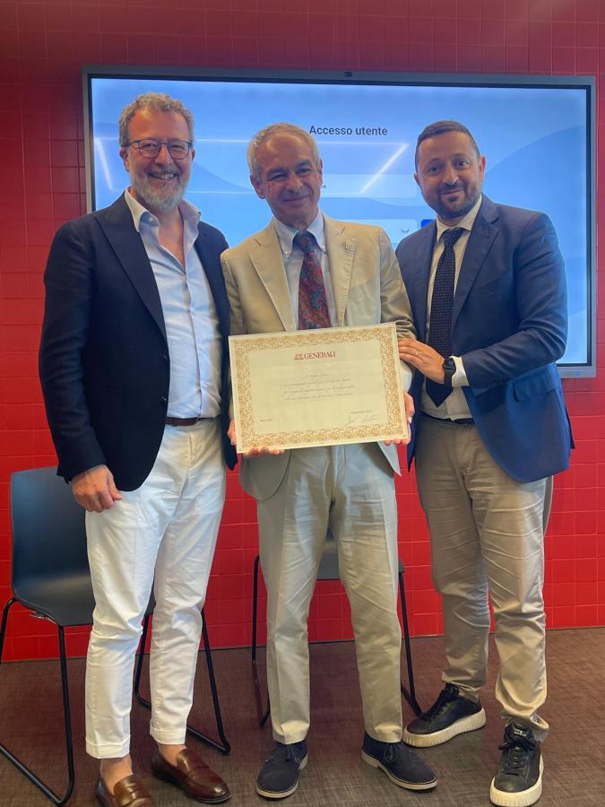 Stefano Cenni riceve un premio per i 40 anni di carriera, circondato da membri della compagnia Generali e colleghi, in un evento speciale.