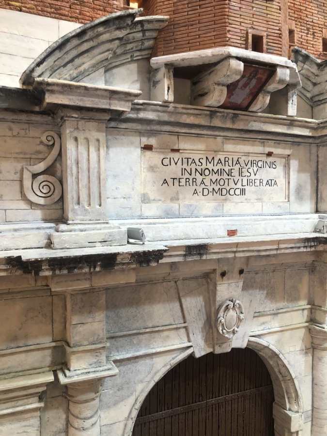 Dettaglio della replica della Porta Romana, opera in scala dell'artigiano Andrea Ceccarelli, con iscrizione storica su marmo e architettura decorativa.