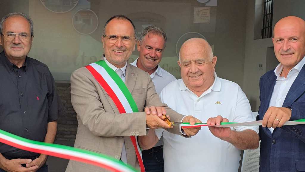Inaugurazione dell'ex mattatoio a Costano, con il sindaco e altre autorità locali che tagliano il nastro tricolore.
