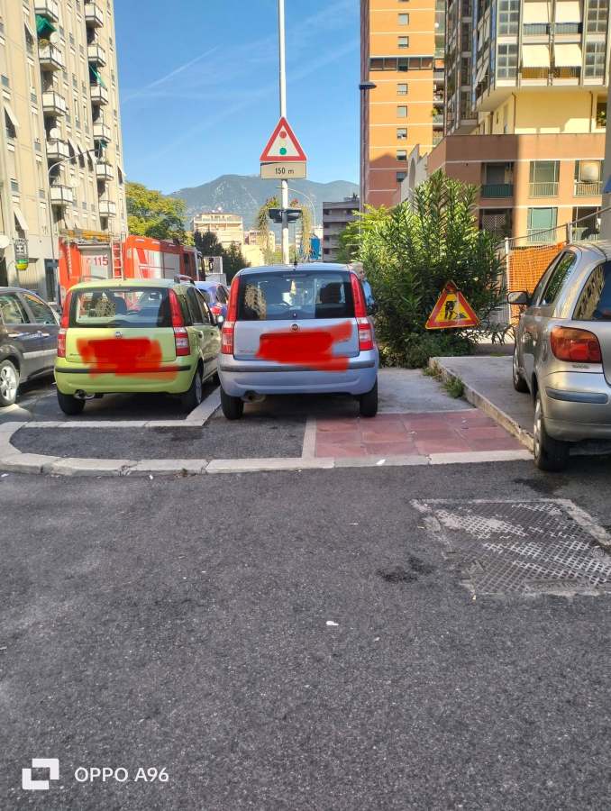 Automobili parcheggiate sopra il marciapiede in una via di Terni, ostacolando il passaggio dei pedoni.