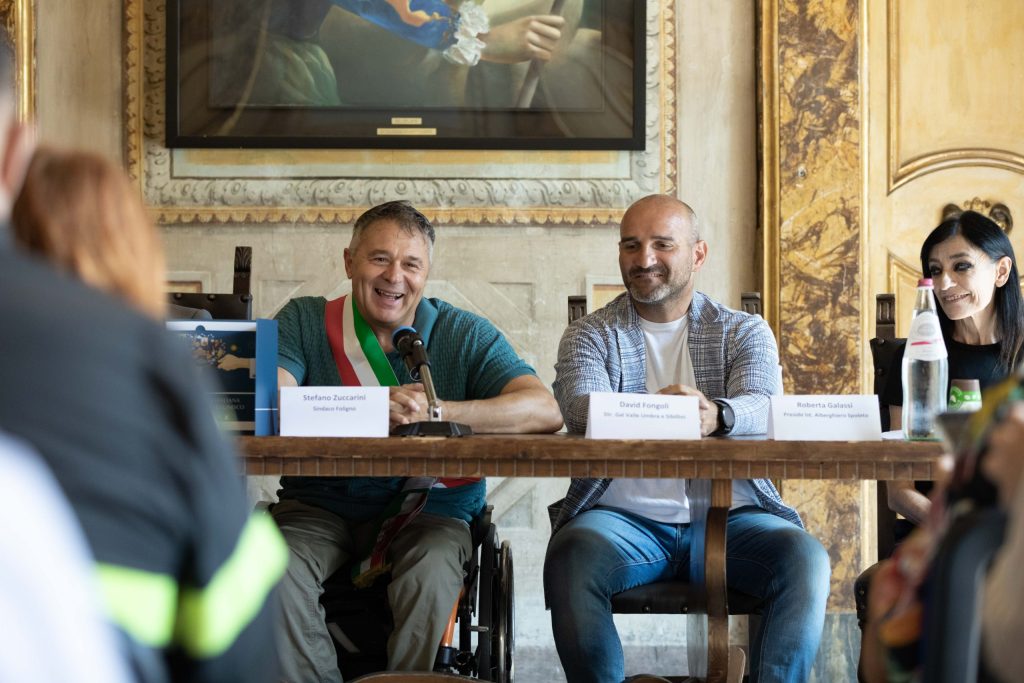 Un incontro durante la presentazione della 26ª edizione de I Primi d'Italia, con il Sindaco di Foligno Stefano Zuccarini e altri relatori, in un ambiente elegante.