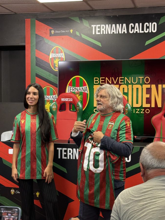 Claudia Rizzo during her first press conference as president of Ternana Calcio, wearing a team jersey alongside a supporter in a similar outfit.