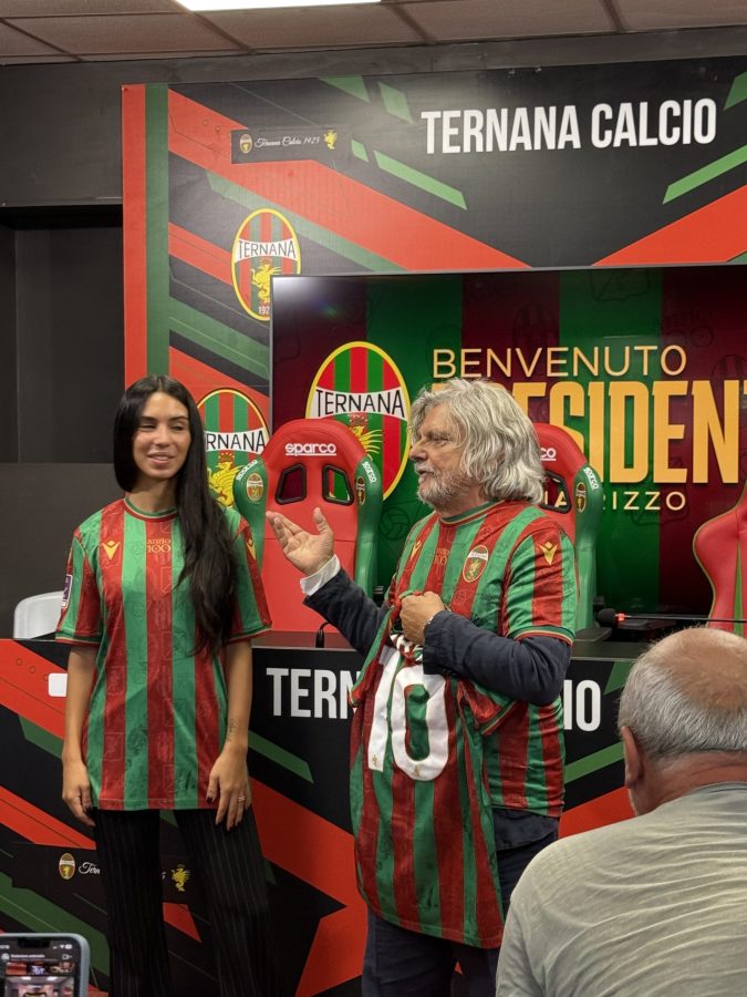 Claudia Rizzo, nuova presidente della Ternana Calcio, appare durante la conferenza stampa indossando la maglietta della squadra, al fianco di Massimo Ferrero, mentre discute del suo nuovo incarico.