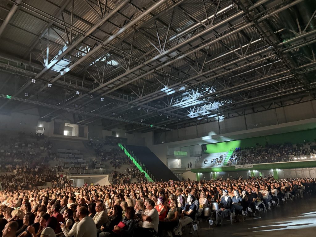 Una grande folla di spettatori assiste al concerto di Francesco Renga al PalaTerni, illuminato da luci e con un'acustica che cattura l'energia del momento.