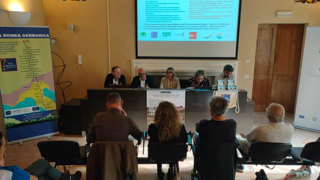 Conferenza sul tema dei cammini, con vari relatori seduti al tavolo e pubblico in ascolto, durante un evento a Paciano.