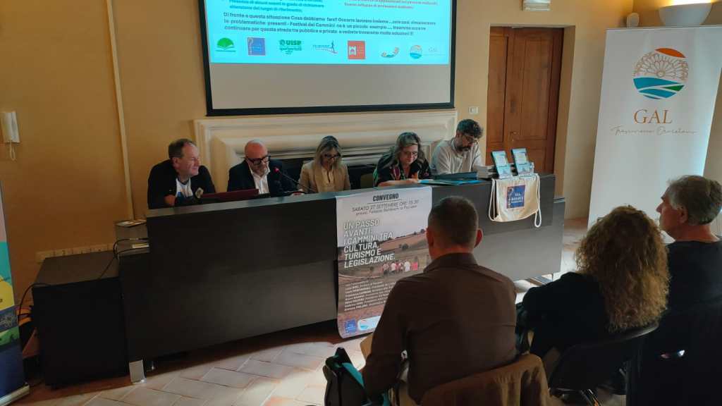 Un incontro al convegno sulla promozione dei cammini in Umbria, con relatori che discutono in un ambiente conferenziale.