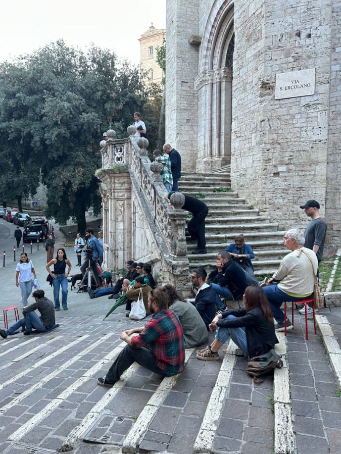 Persone sedute lungo le scalette di Sant'Ercolano a Perugia, partecipando al primo episodio di 'Radio Edicola'.