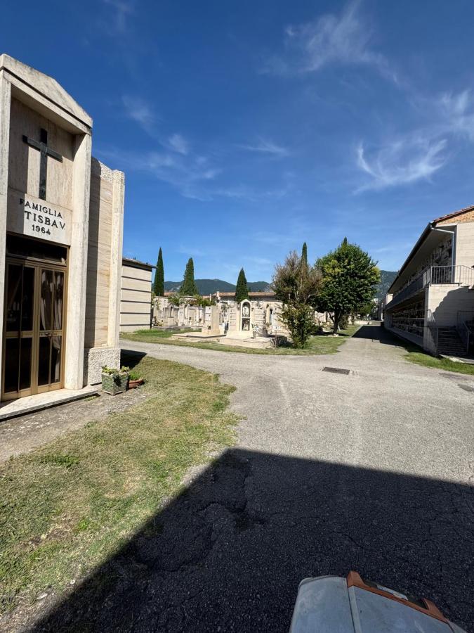 A cemetery scene featuring gravestones and memorials, with cypress trees and blue skies in the background.