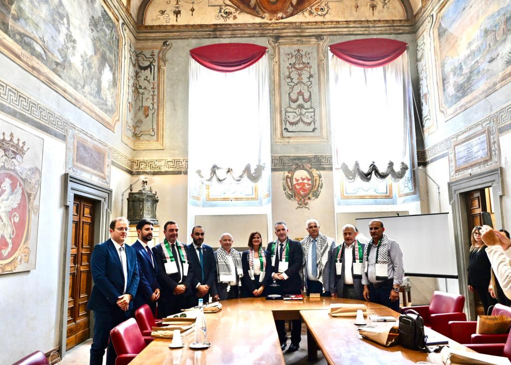 Delegazione palestinese e rappresentanti del Comune di Perugia durante un incontro ufficiale a Palazzo dei Priori, evidenziando il dialogo e la solidarietà.