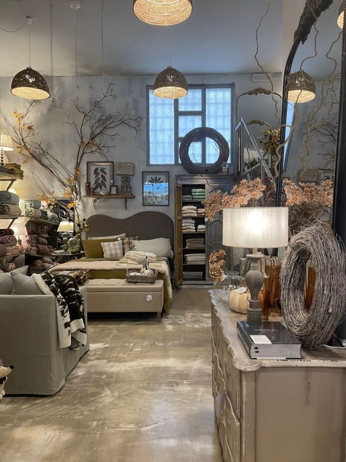 Interno del negozio "Pan di Zucchero" con arredi e decorazioni per la casa, illuminato da lampade sospese e caratterizzato da tonalità calde e accoglienti.