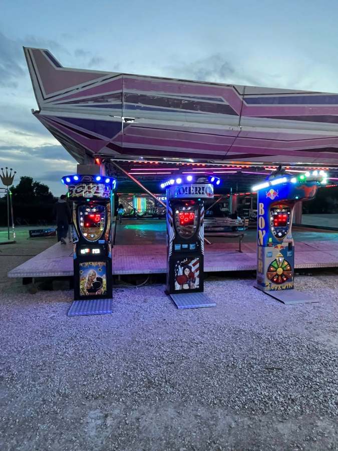 Macchine da gioco illuminate in un luna park al centro fiere di Montecastrilli, di sera.
