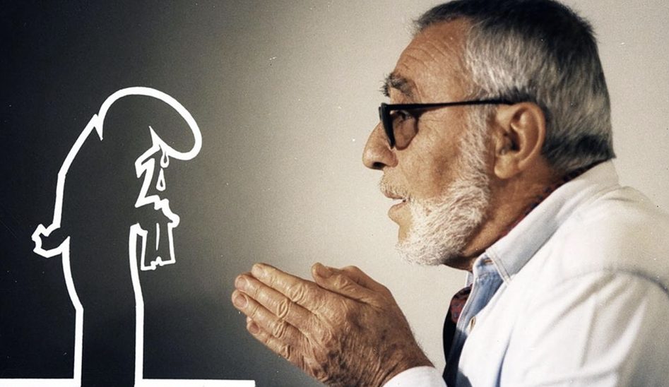 Un uomo anziano con occhiali e barba bianca sta parlando, mentre una sagoma stilizzata di un personaggio triste con una lacrima è visibile sullo sfondo.