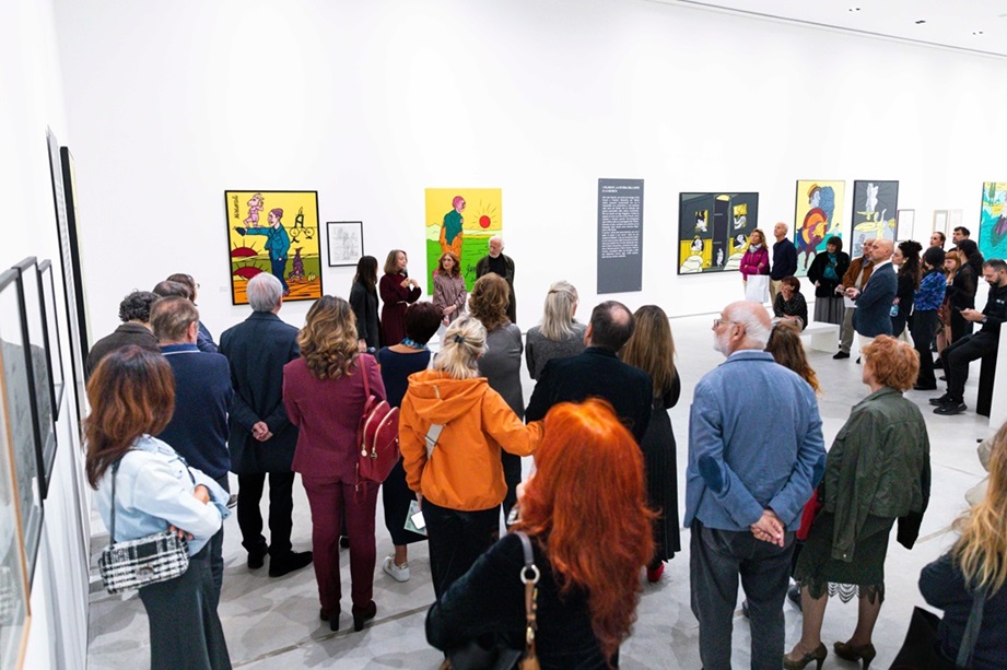 Visitatori all'inaugurazione della mostra di Valerio Adami presso il CIAC di Foligno, con opere esposte sulle pareti.