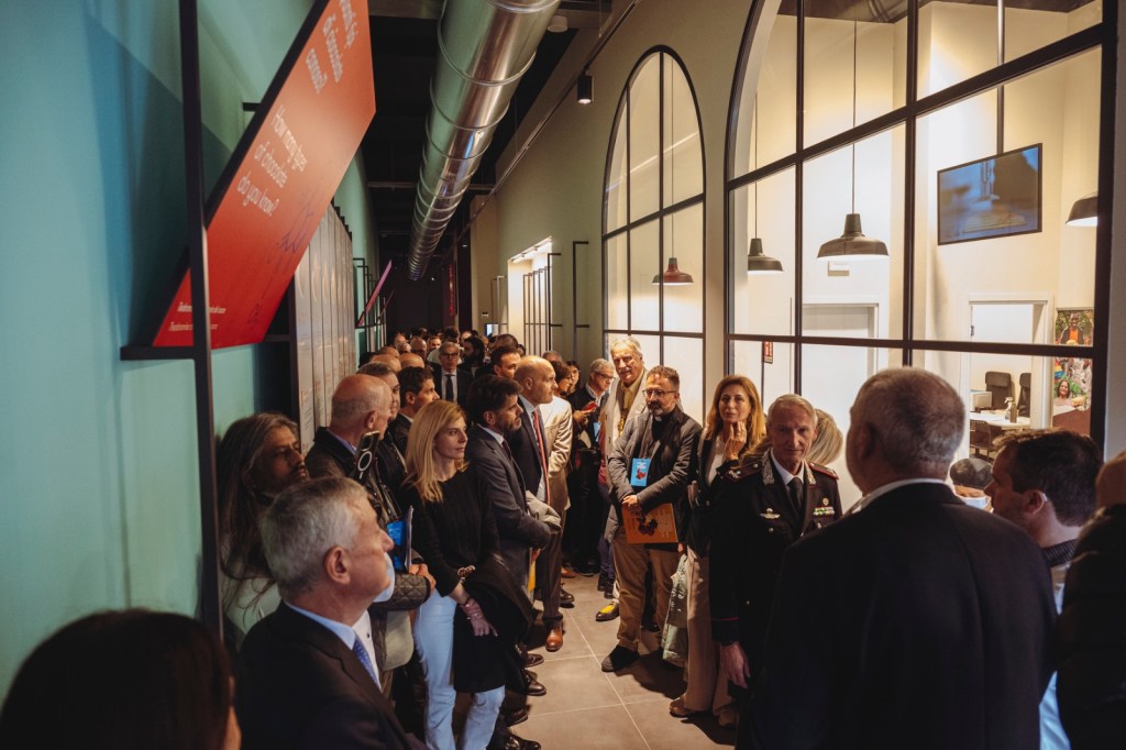 Un gruppo di persone in un corridoio del nuovo museo Città del Cioccolato di Perugia, con pareti colorate e decorazioni moderne.