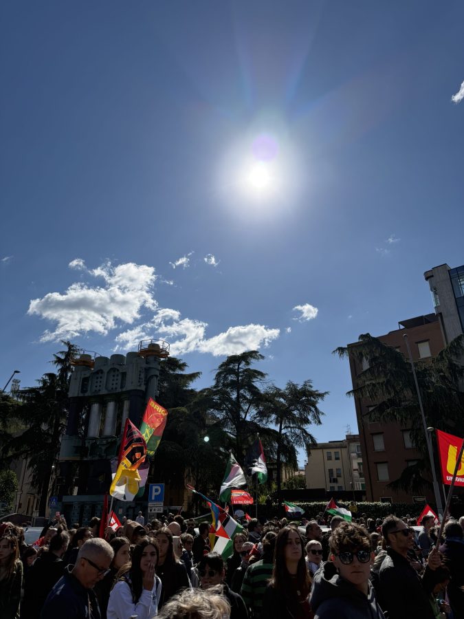 Una grande manifestazione di persone in piazza, con bandiere e cartelli, sotto un cielo soleggiato a Terni.