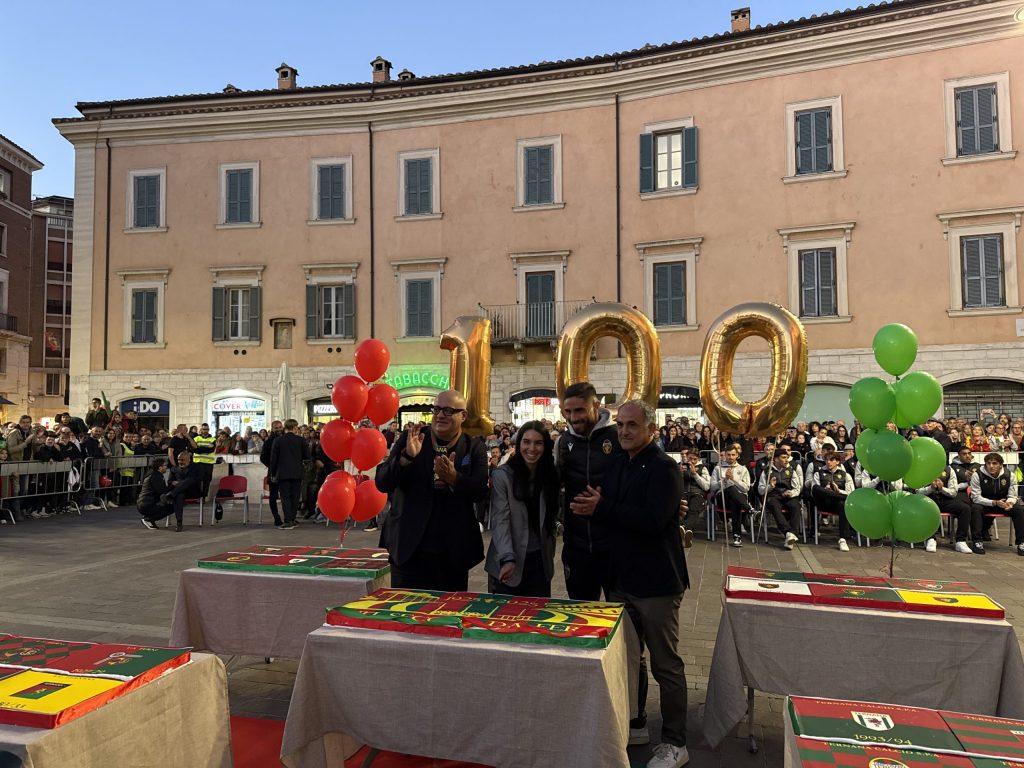 Celebrazione della Ternana in piazza della Repubblica, con membri della squadra e personale, durante un evento pubblico con decorazioni e palloncini.