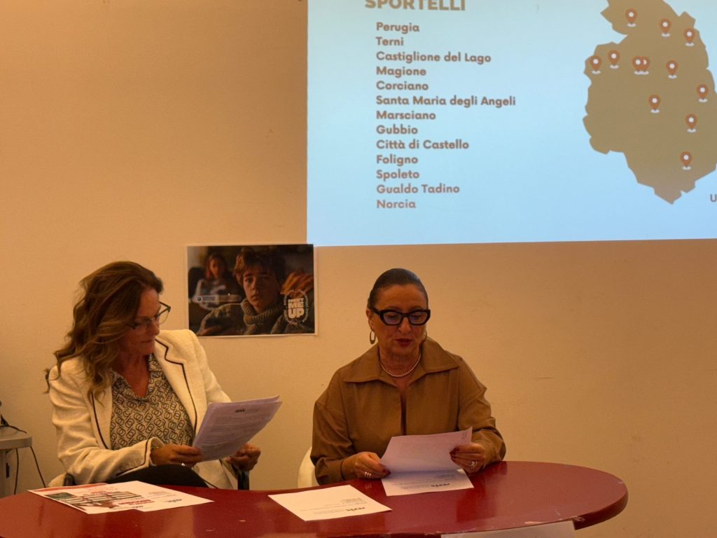 Due donne sedute a un tavolo mentre leggono documenti, con una mappa delle località dei punti di ascolto sullo sfondo.