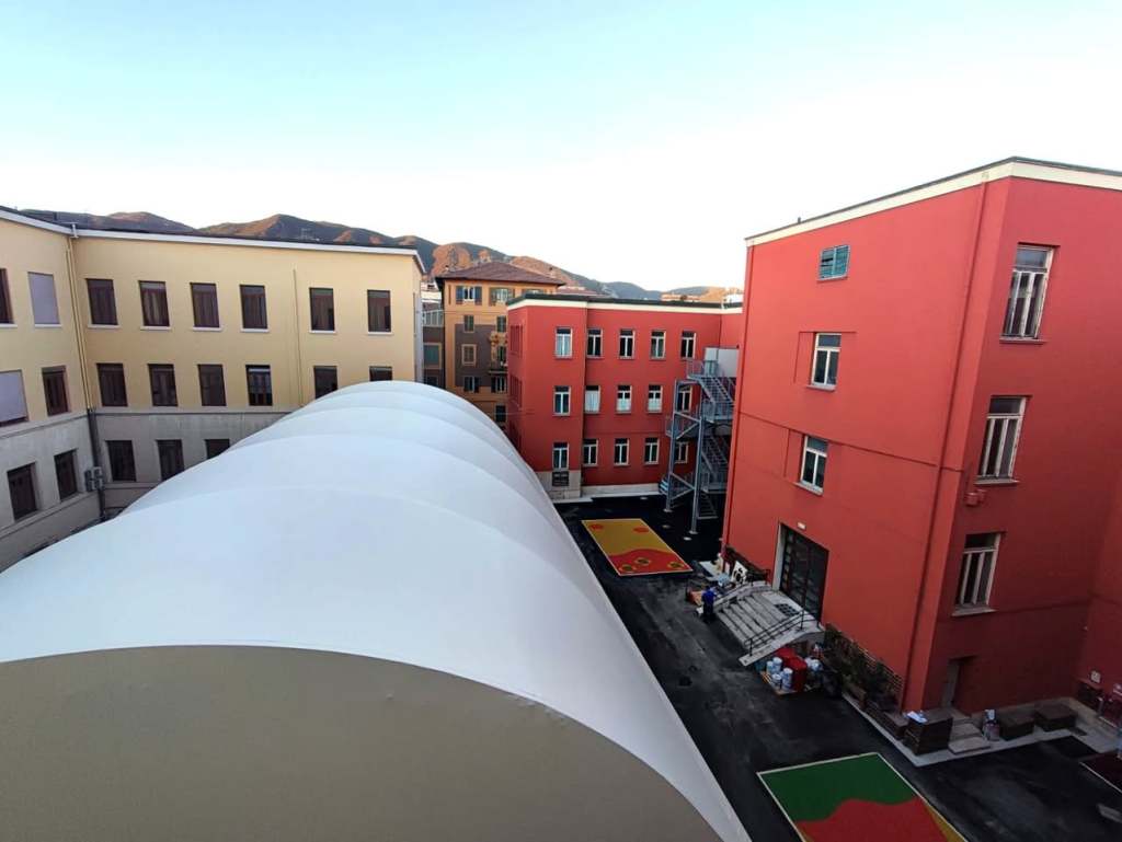 Vista della nuova palestra del Liceo Classico Tacito di Terni, con una struttura coperta e edifici circostanti in un'area scolastica.