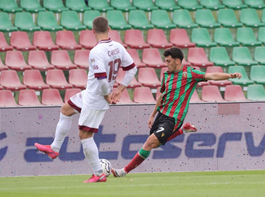 Un giocatore della Ternana cerca di calciare il pallone mentre un avversario dell'Arezzo si prepara a difendere, in un momento di azione durante una partita di calcio.