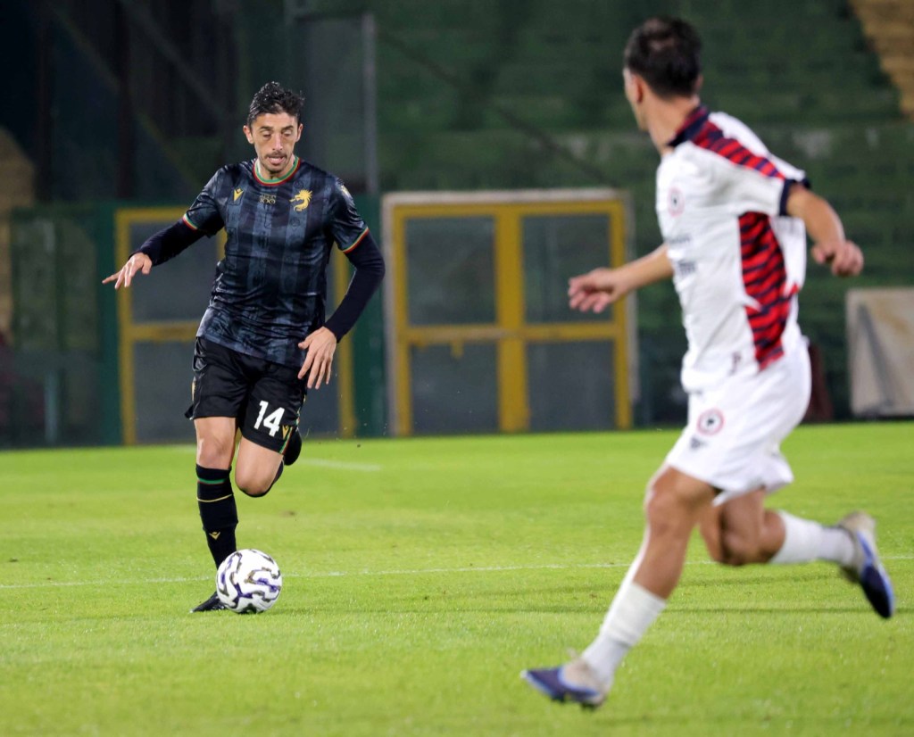 Giocatore della Ternana in azione con la maglia numero 14, mentre dribbla un avversario del Campobasso durante una partita di calcio.
