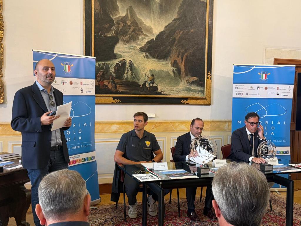 Un evento che celebra il primo memorial D'aloja dedicato alla sostenibilità, con relatori e panel in una sala elegante.