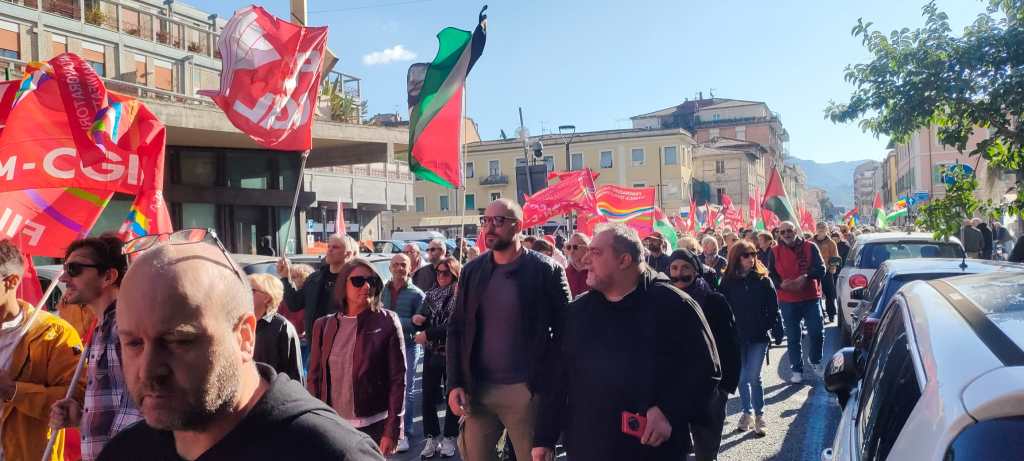 Manifestazione con partecipanti che sfilano in strada, portando bandiere della CGIL e della Palestina, durante una marcia per solidarietà con il popolo palestinese a Terni.