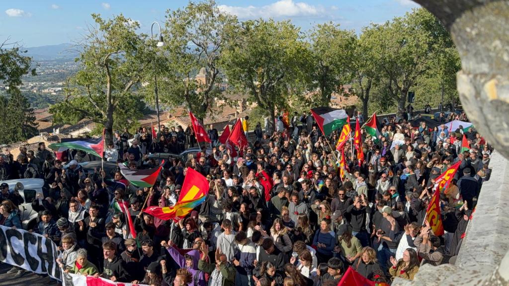 Manifestanti in marcia a Perugia, con bandiere palestinesi e striscioni, durante un corteo per la pace.