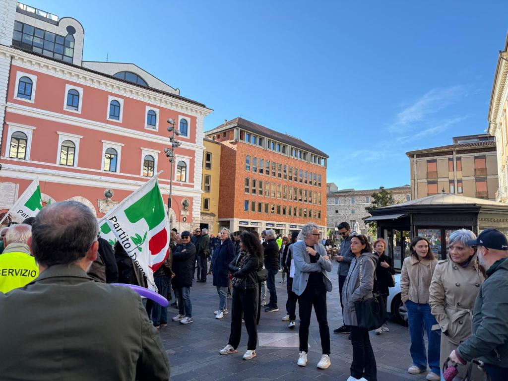 Una folla di persone in piazza della Repubblica a Terni, con bandiere del Partito Democratico, durante una manifestazione di protesta contro il sindaco.