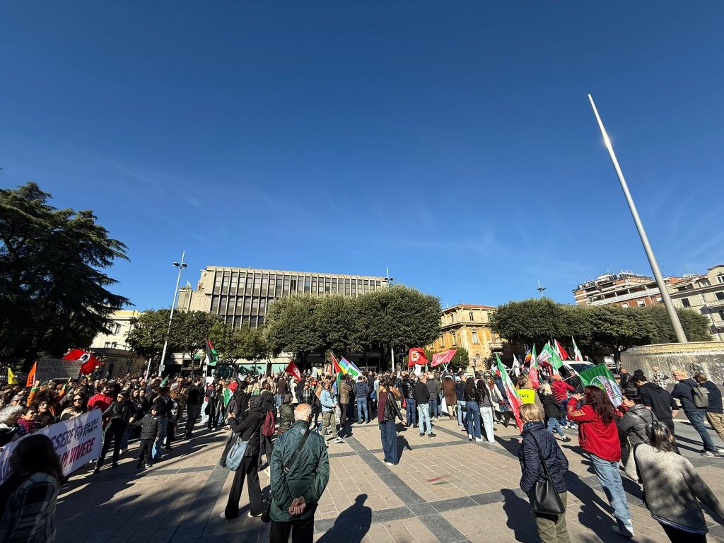 Un'ampia folla si riunisce in piazza della Repubblica a Terni durante una protesta con manifesti e bandiere rossogreen, chiedendo le dimissioni del sindaco Stefano Bandecchi.