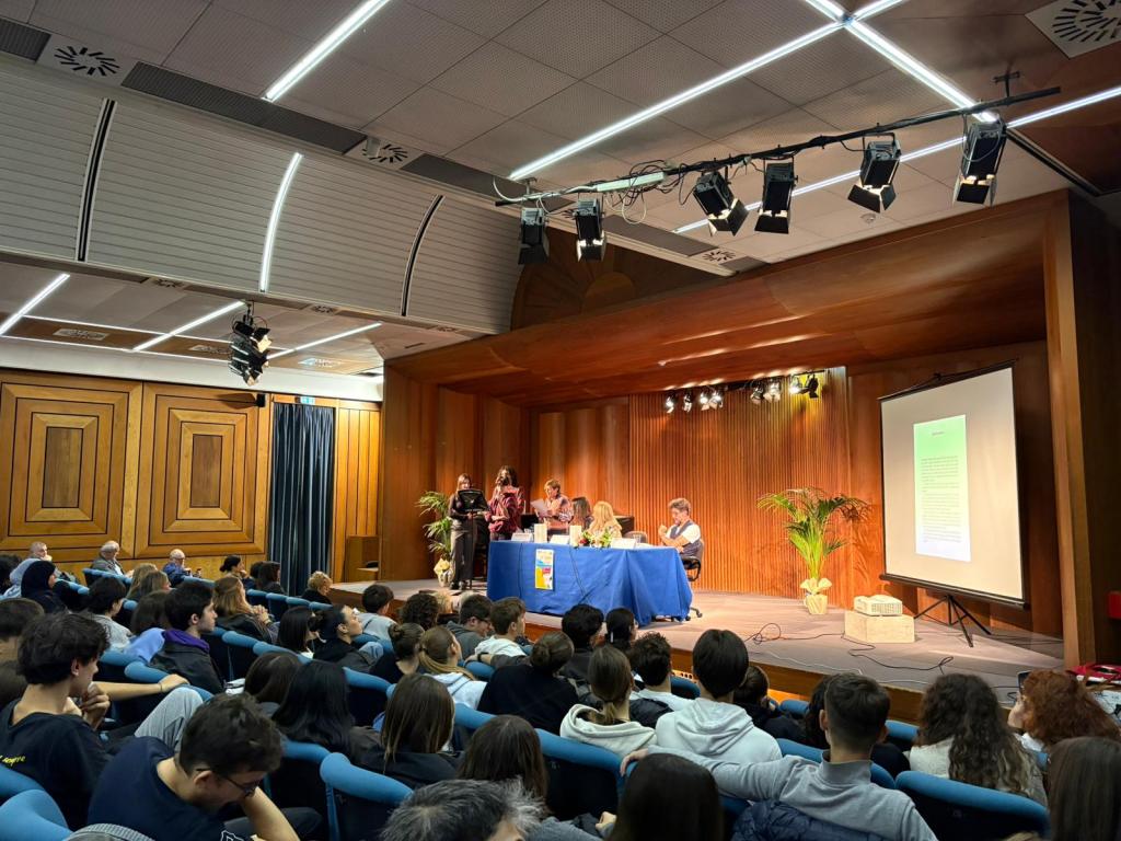 Un evento presso la sala blu di Palazzo Gazzoli con una cerimonia di consegna borse di studio, studenti e docenti in un'atmosfera di celebrazione culturale.